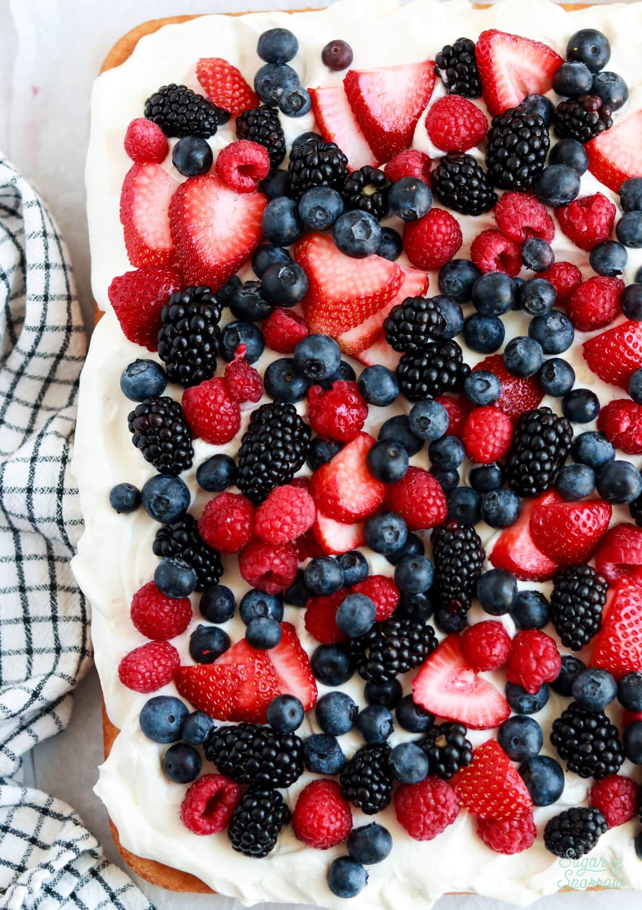 cake with whipped cream frosting and berries