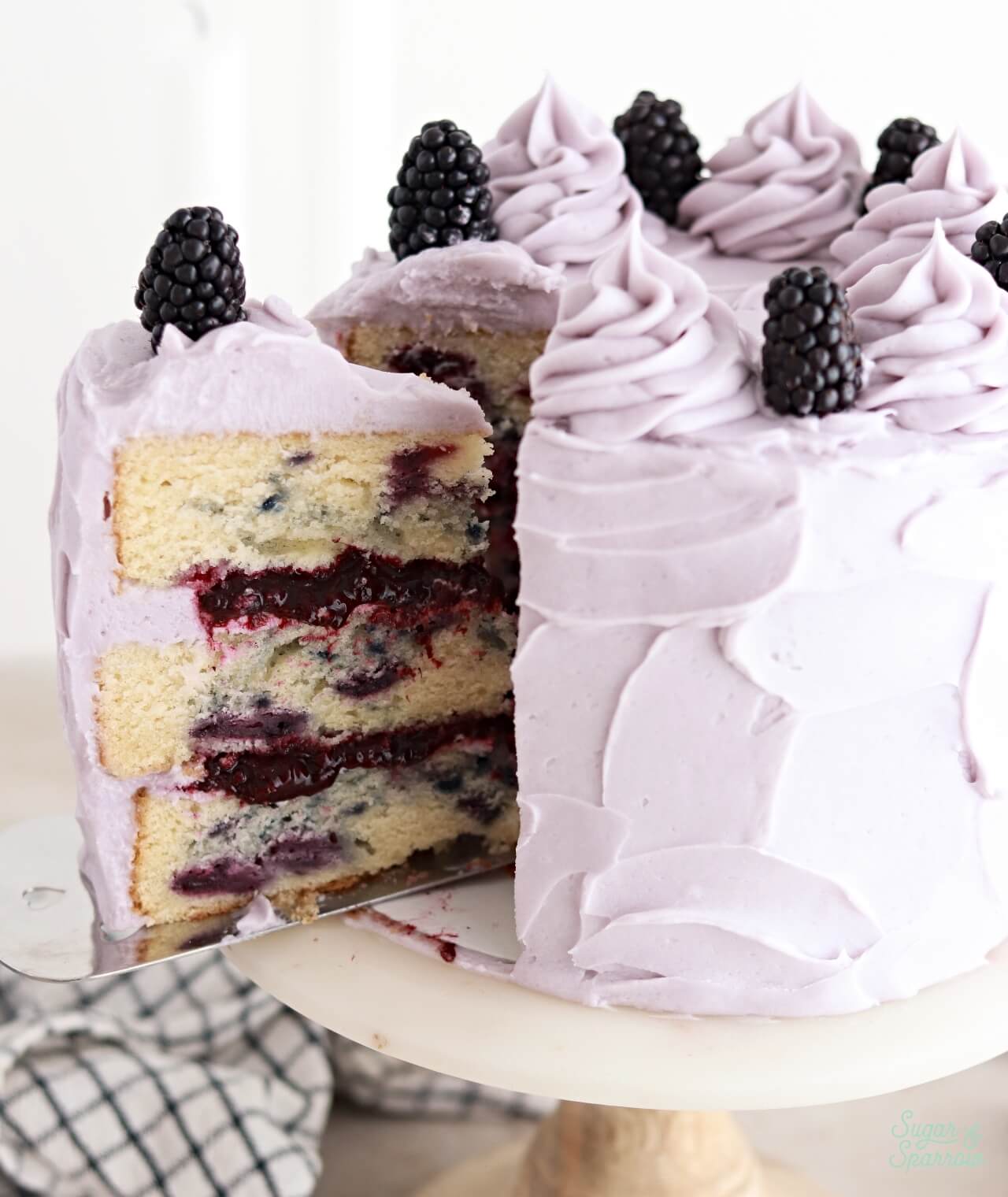 blackberry lavender layer cake with a slice reveal