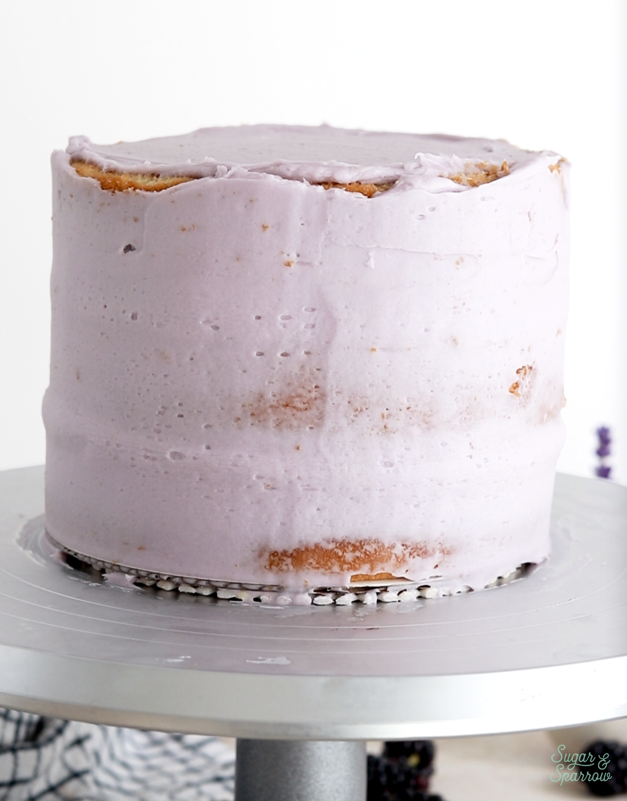 crumb coating blackberry cake with lavender buttercream
