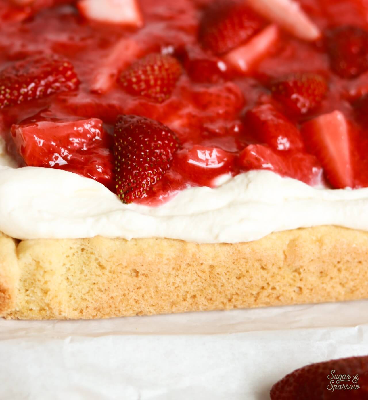 sugar cookie bars with whipped cream frosting and strawberries