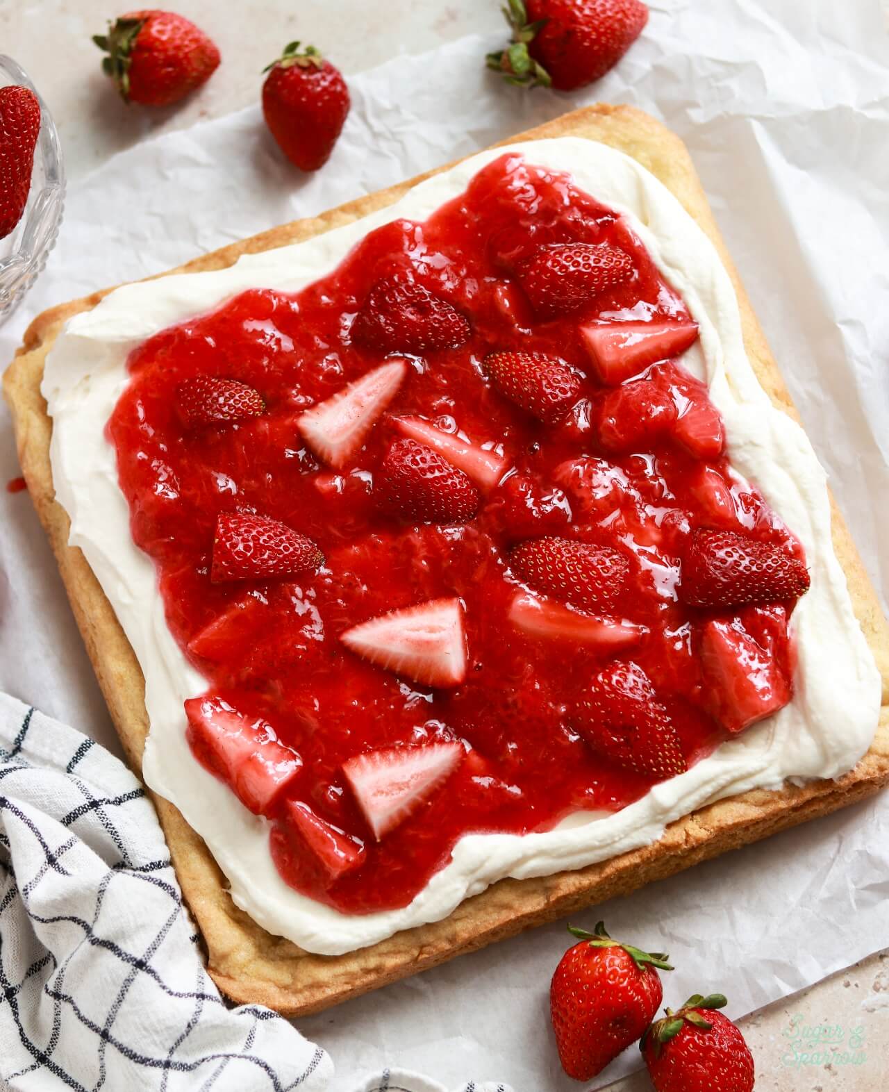 strawberry shortcake sugar cookie bars with whipped cream cheese frosting and strawberry sauce