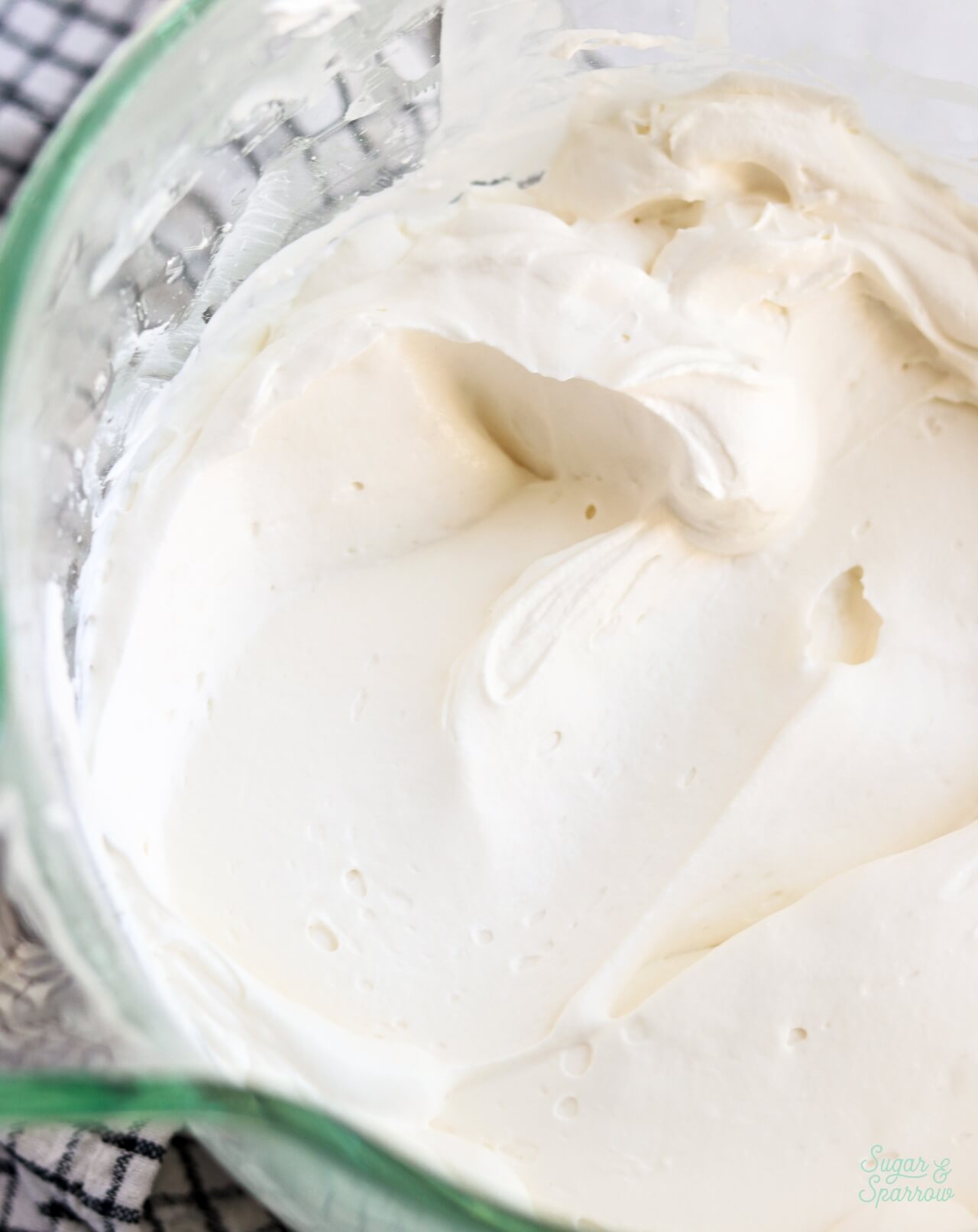 whipped cream cheese frosting in a glass mixing bowl