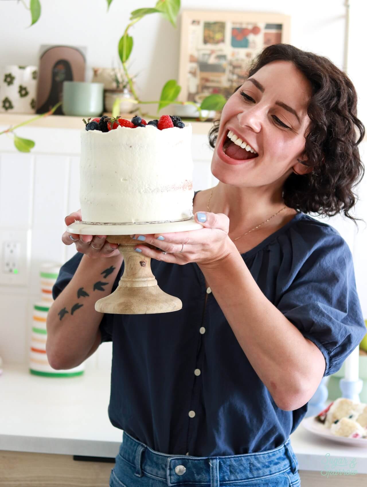 whitney depaoli sugar and sparrow holding berries and cream layer cake
