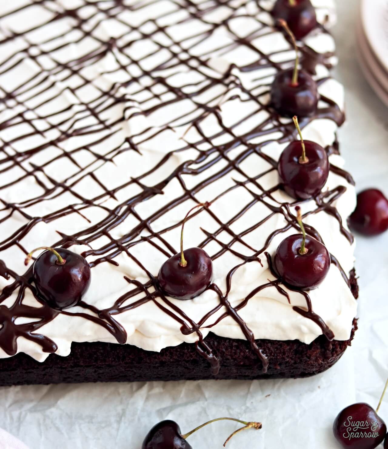 easy black forest sheet cake with homemade cherry filling and whipped cream frosting
