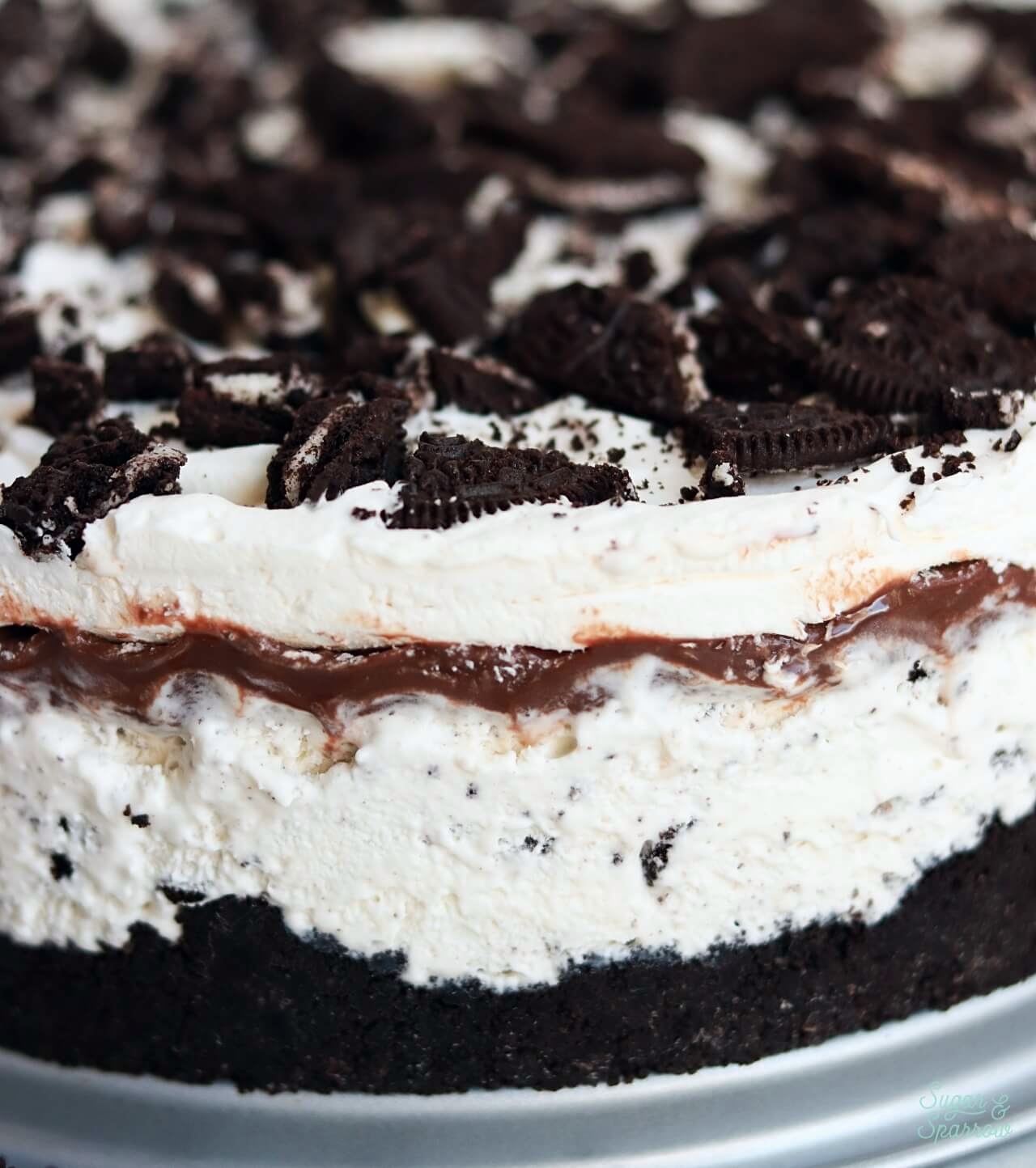 cookies and cream ice cream cake with oreo cookie crust and hot fudge layers