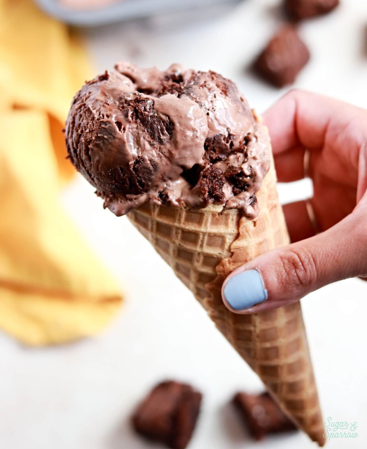 chocolate brownie ice cream in a waffle cone
