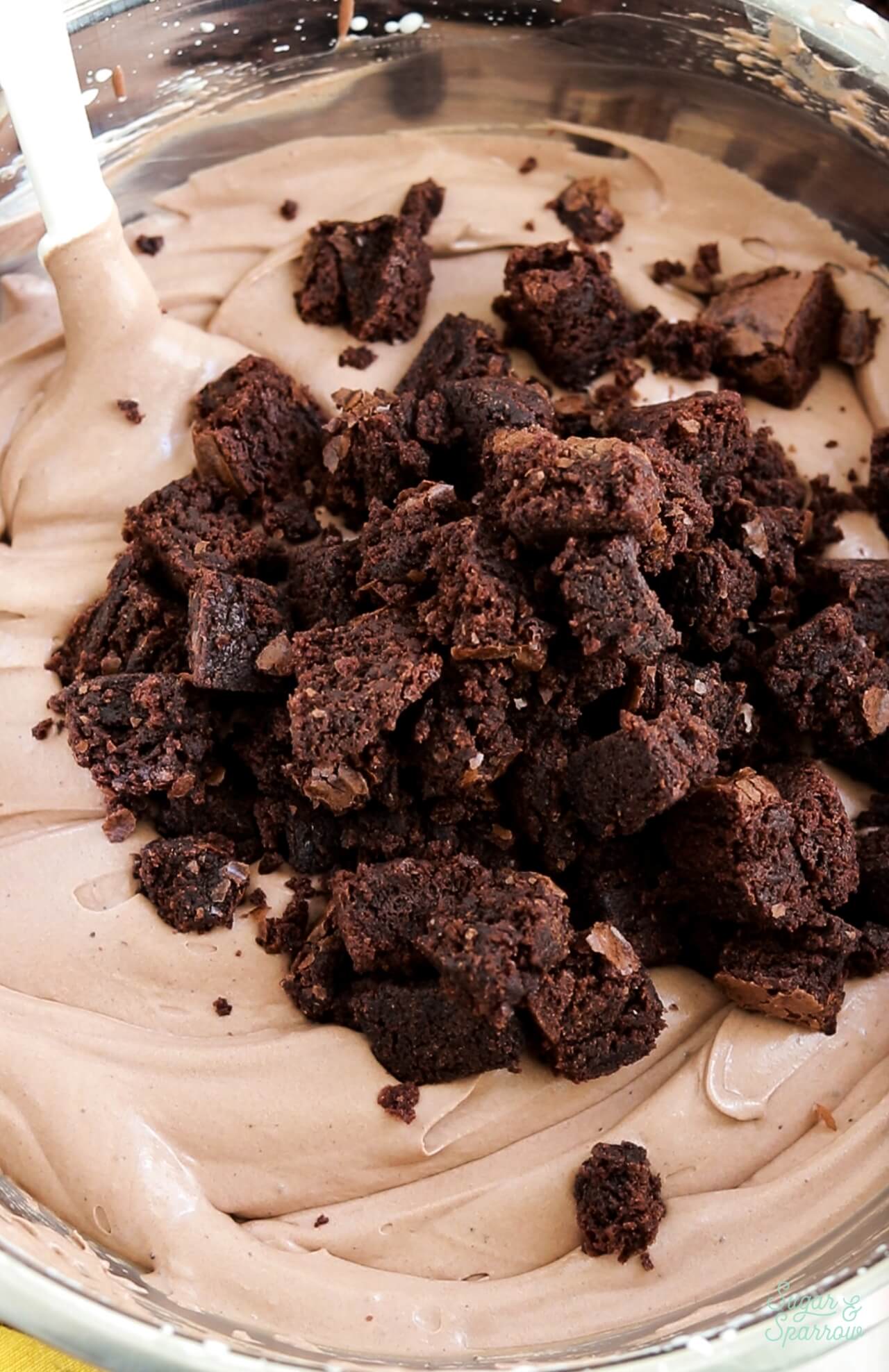 folding brownie bites into no churn chocolate ice cream