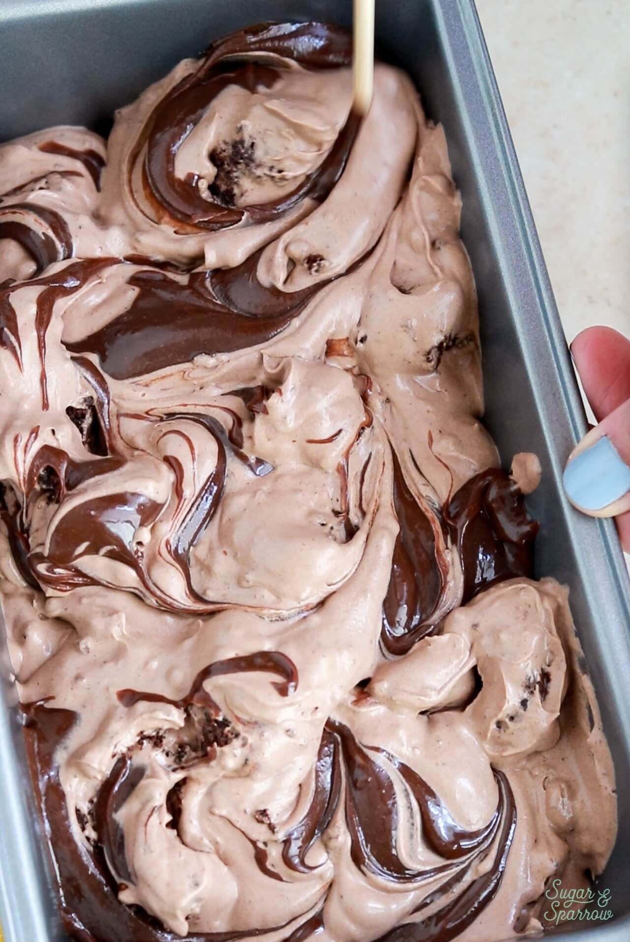 assembling no churn chocolate brownie ice cream in a loaf pan