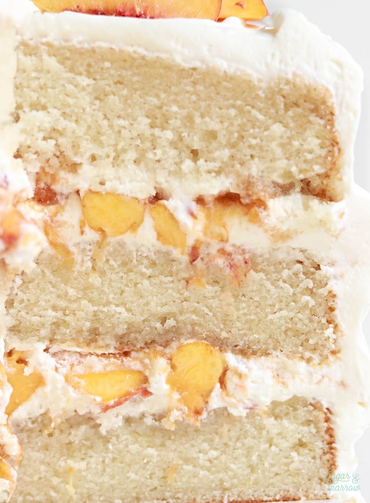 peaches and cream layer cake with whipped cream frosting and brown sugar peaches