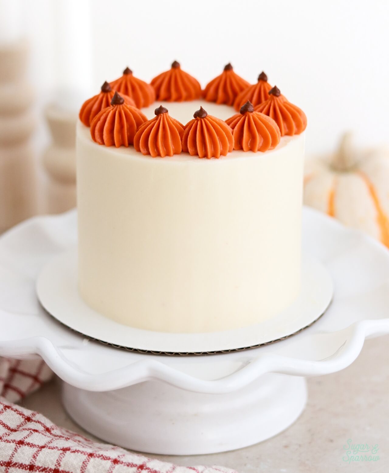 mini pumpkin layer cake with buttercream piped pumpkins on top