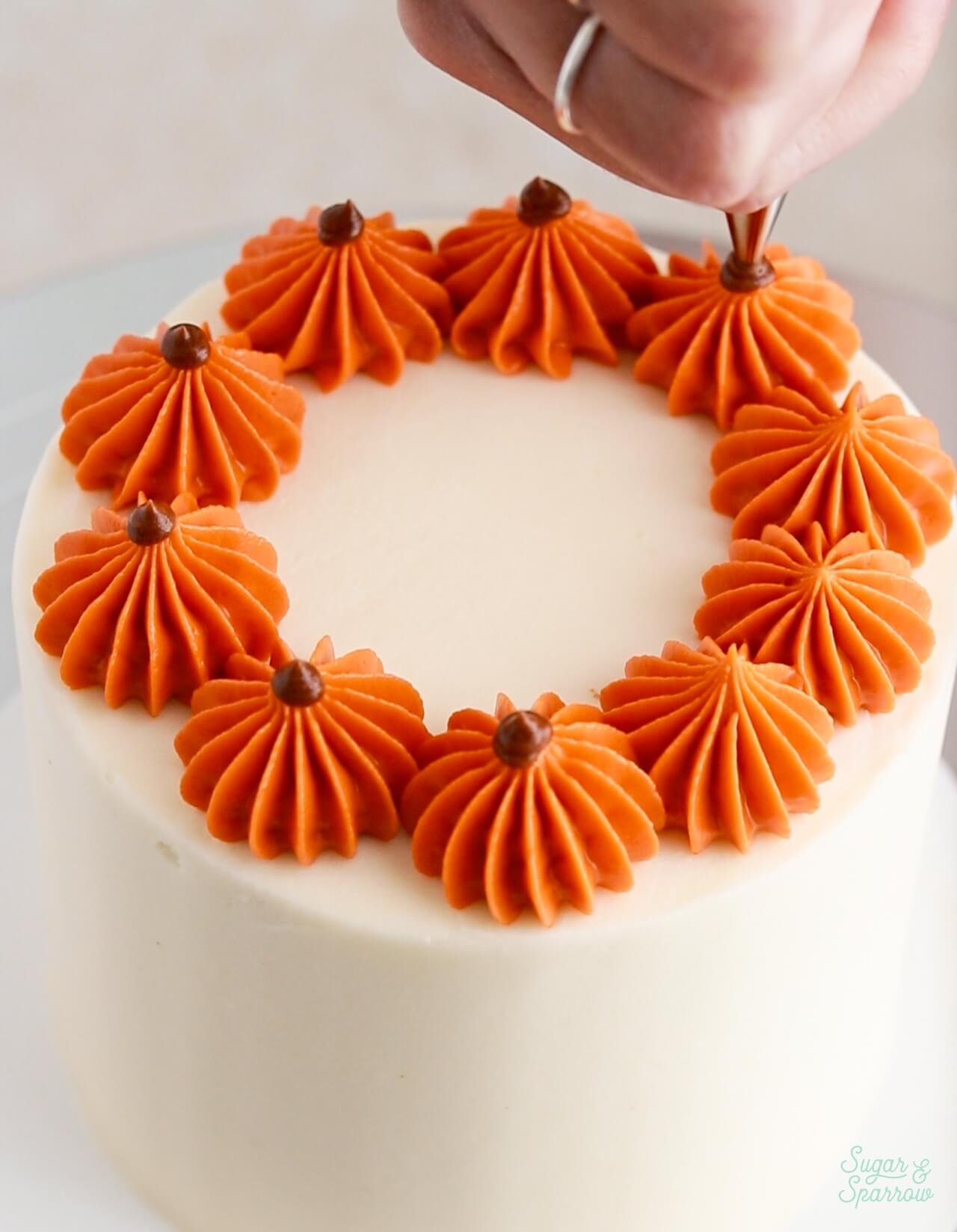 piping pumpkins on cake with buttercream