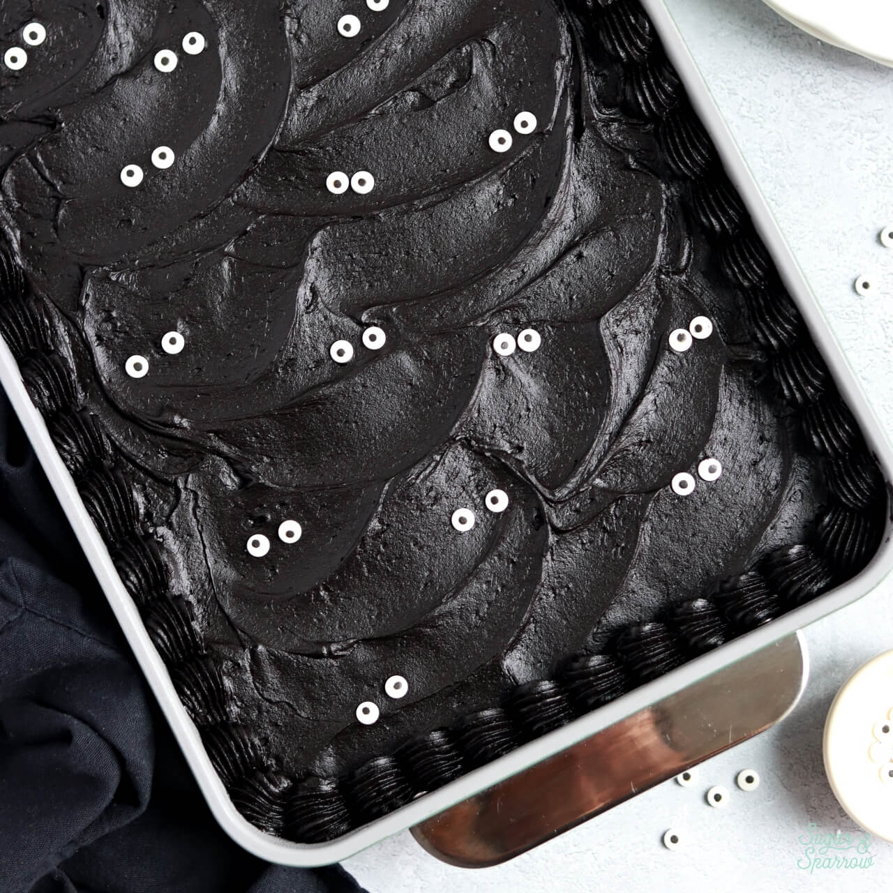 black velvet cake baked in a 9x13 pan decorated with black buttercream and googly eyes