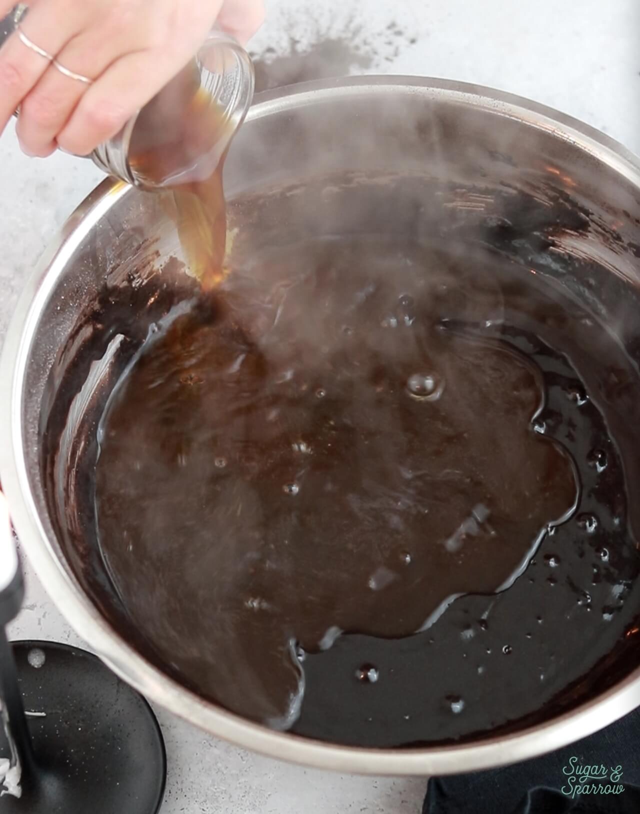 adding hot coffee to chocolate cake batter