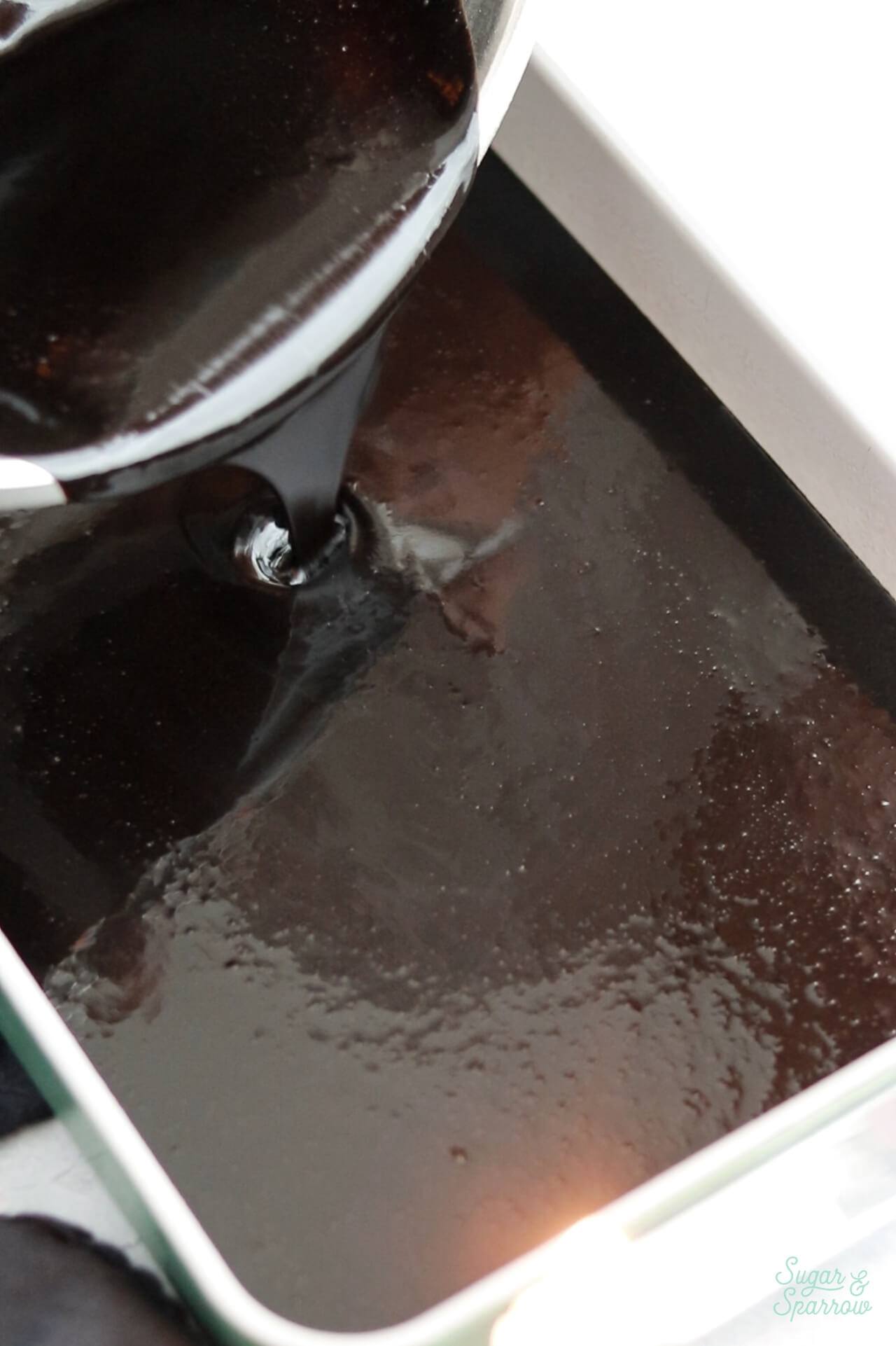 pouring black velvet cake batter into 9x13 pan