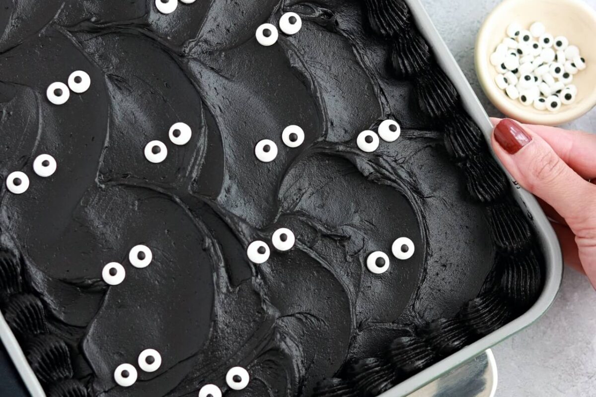 black velvet cake baked in a 9x13 pan decorated with black buttercream and googly eyes