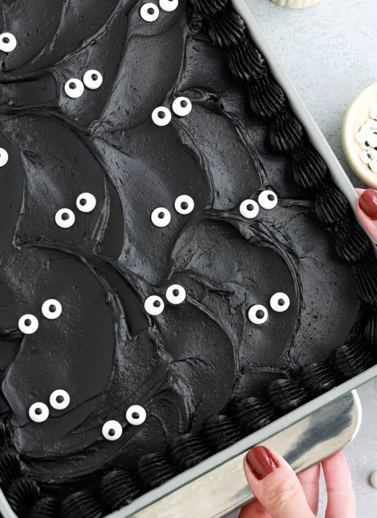 black velvet cake baked in a 9x13 pan decorated with black buttercream and googly eyes