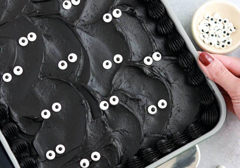black velvet cake baked in a 9x13 pan decorated with black buttercream and googly eyes
